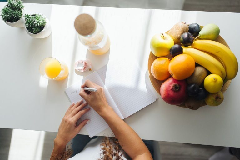 Households Write a Debt Payoff Order and Stick to It notebook and pen on a kitchen table